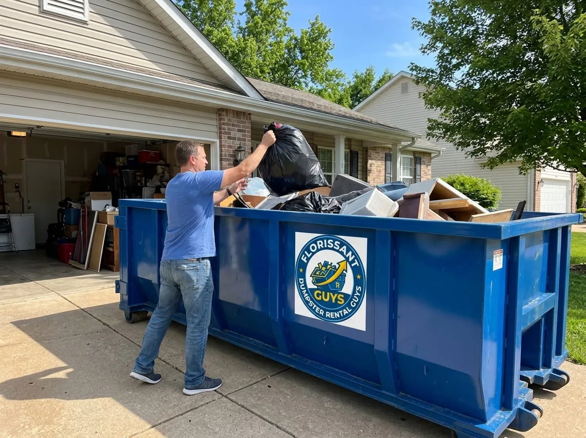 Homeowner loading household junk into a roll-off dumpster in Florissant, Missouri